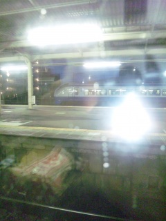 まだ暗い駅。雨ぱらぱら。